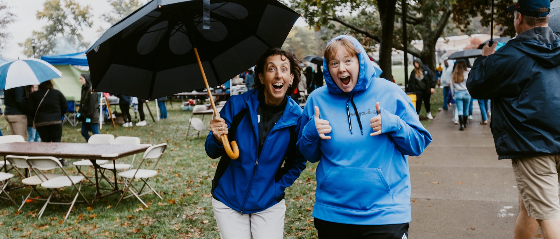 Two CSU alumnae smile happily in the rain